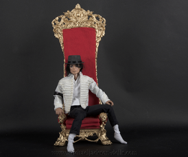 Michael Jackson doll on red chair
